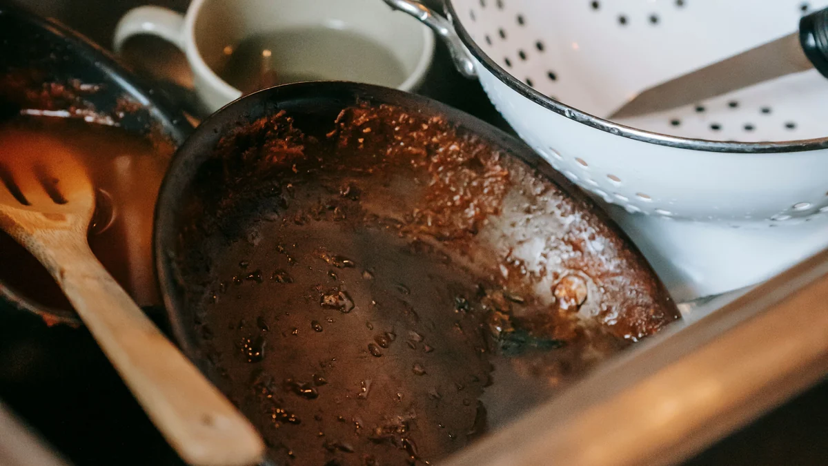 Dirty dishes piled in a kitchen sink in a shared home