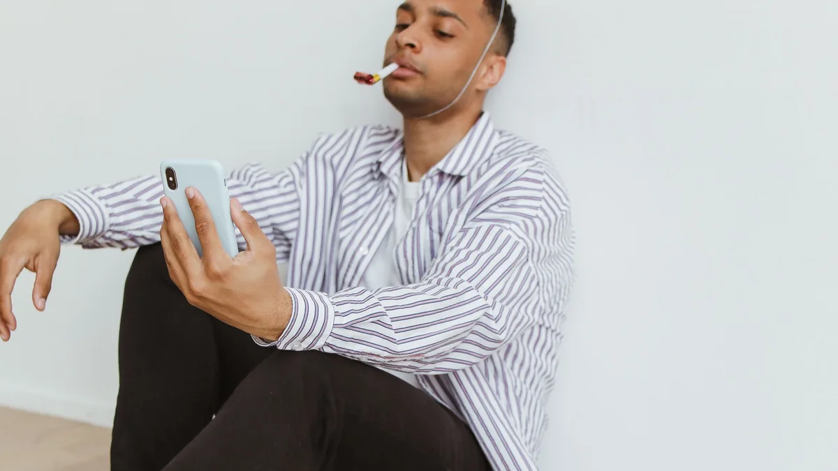 Person checking their phone beside a small birthday celebration