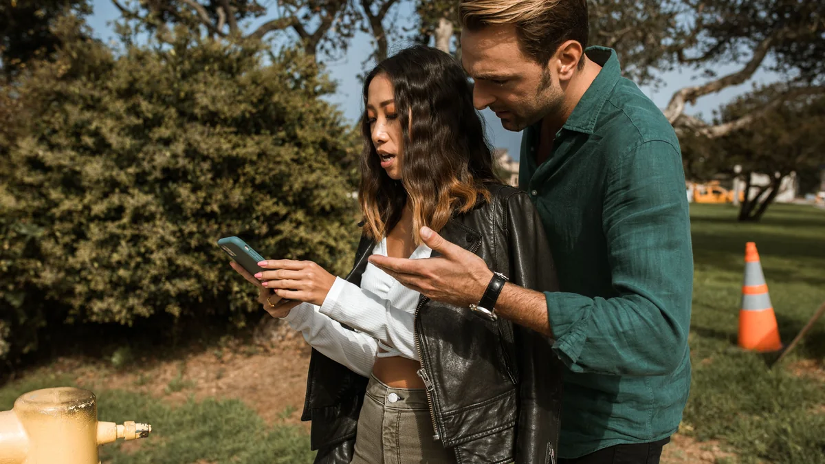 Friends having a tense disagreement while checking messages on a phone