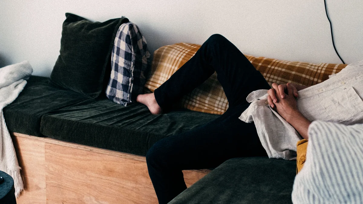 A person relaxing alone on a couch during quiet time at home.
