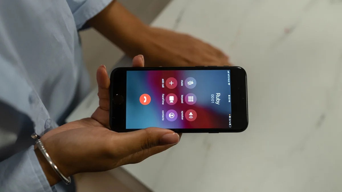 A person holding a smartphone during an incoming phone call.