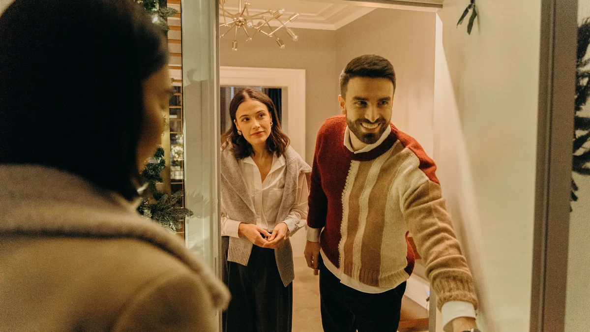 Friends welcoming an unexpected visitor at the front door