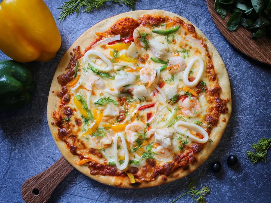 Seafood pizza topped with shrimp, squid and bell peppers.