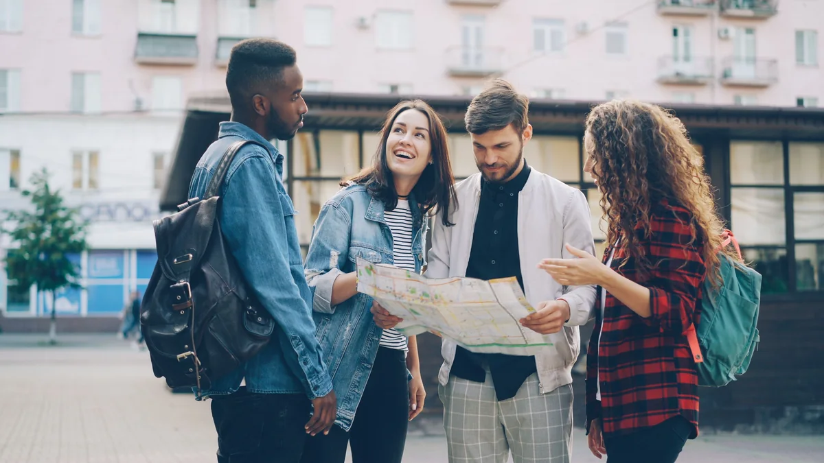 A group of friends using a map while exploring a city on vacation.