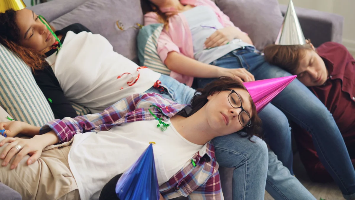 Friends exhausted and sleeping on a couch after a long social event.