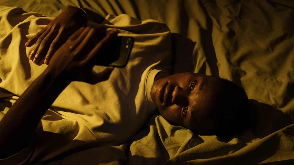 Person using a glowing smartphone late at night in bed