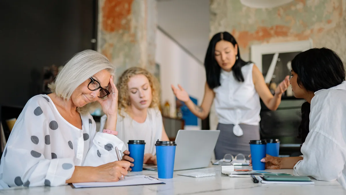 People in a meeting discussing an idea while one person looks unimpressed