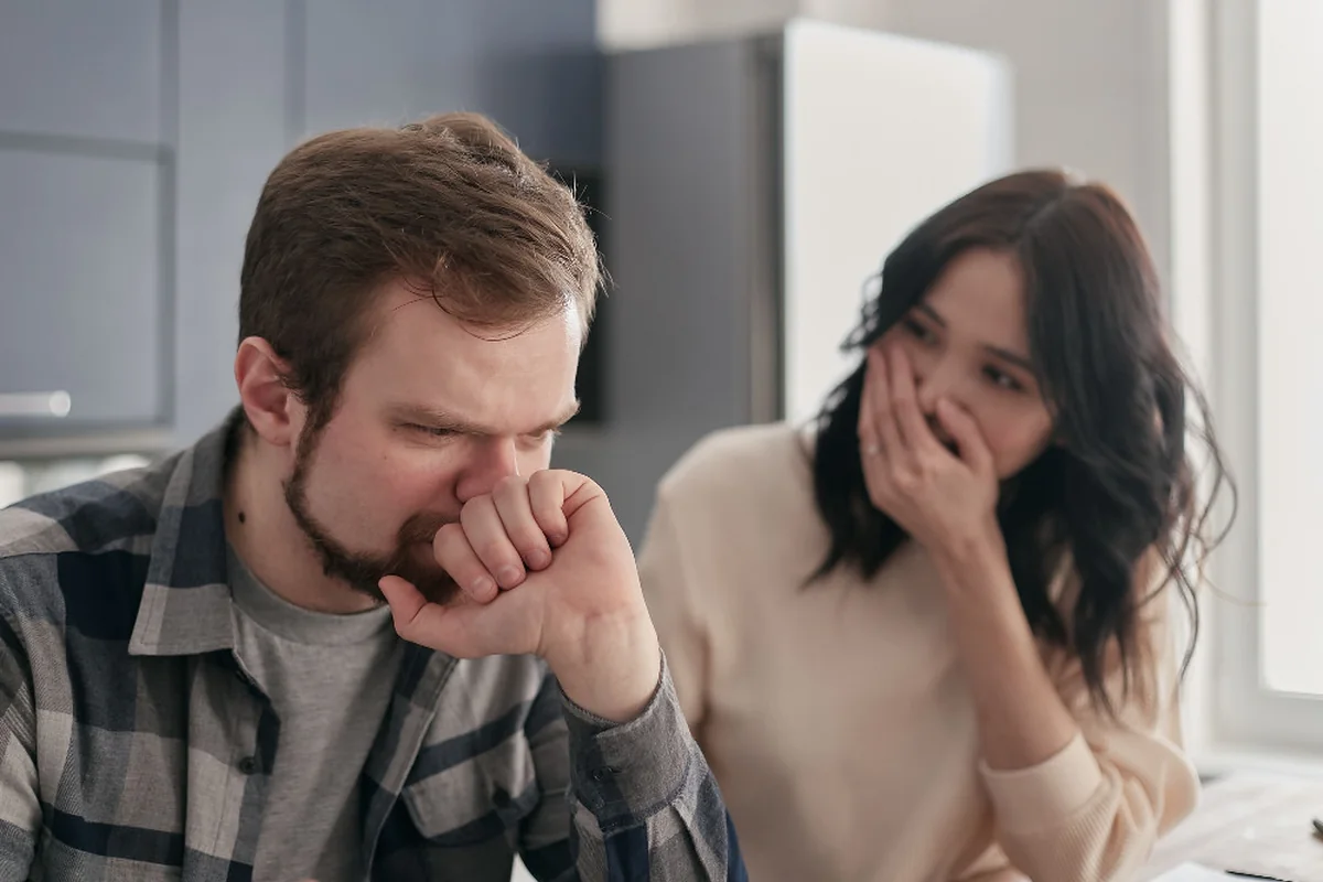 A worried man sitting beside a woman during a serious conversation.