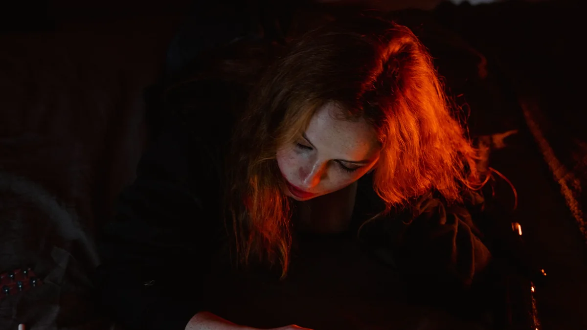 Person using a smartphone in bed late at night before sleeping
