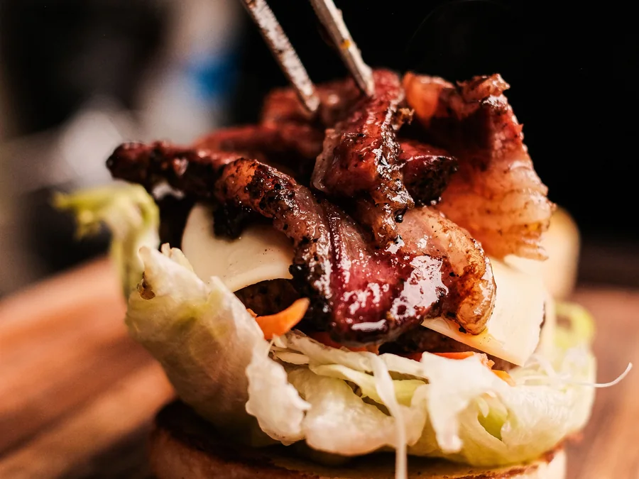 Gourmet burger with bacon and rich toppings.