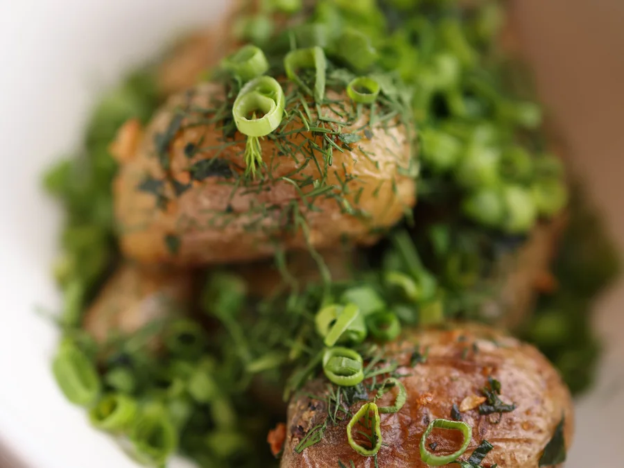 Roasted potatoes garnished with herbs.