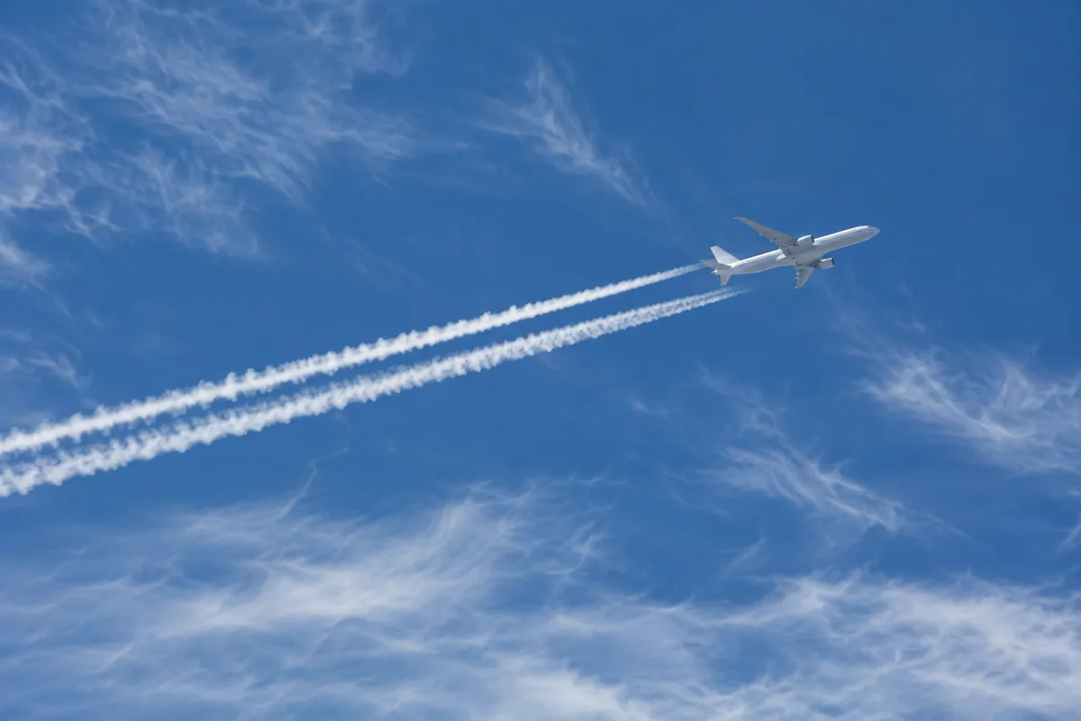Jet airplane leaving a bright white contrail in cold upper-atmosphere conditions